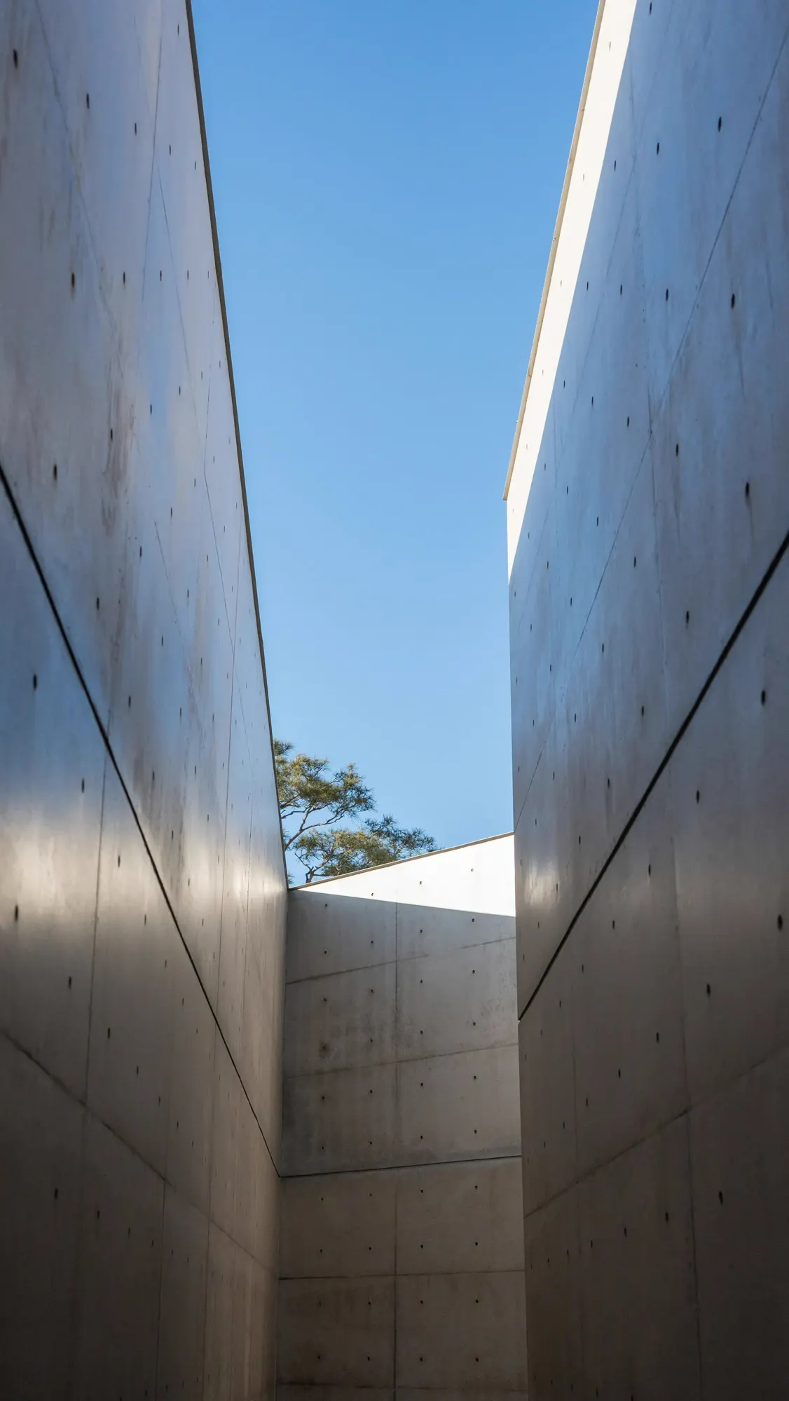 A narrow passage between two tall concrete walls